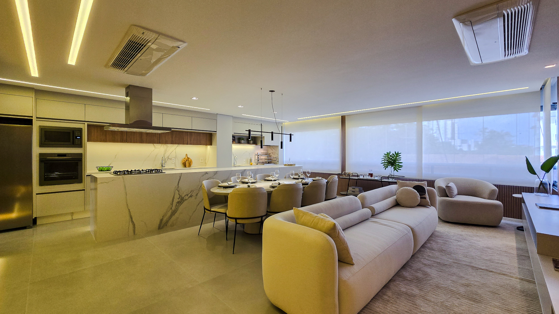 Sala integrada com cozinha planejada em tons claros